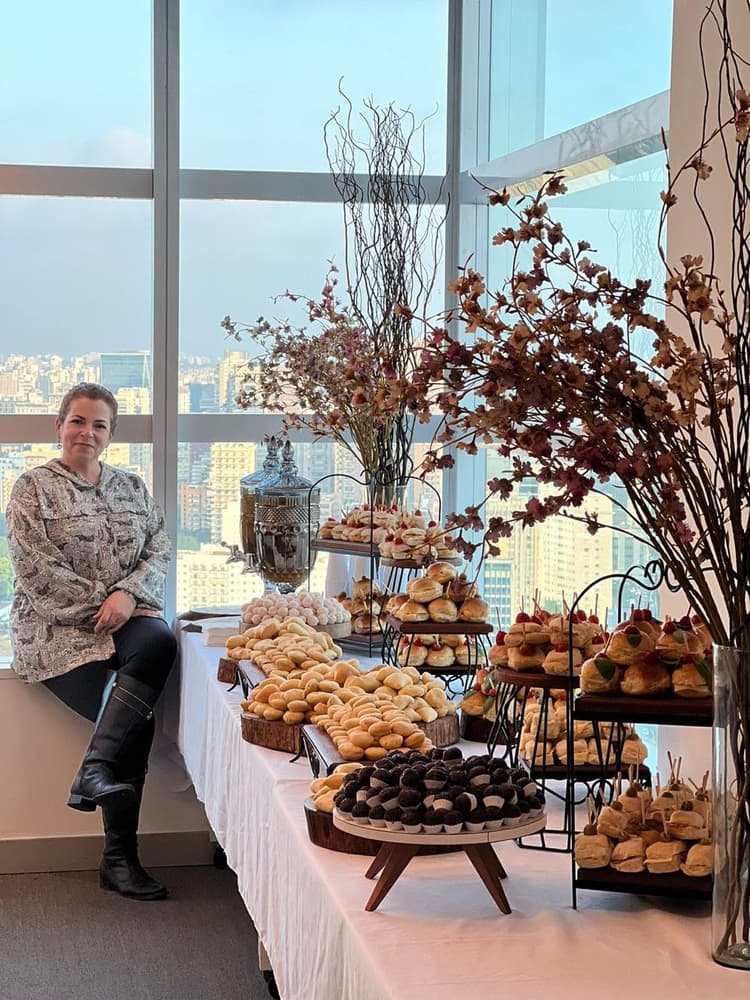 Mesa de Coffee Break empresarial com pães doces frutas e queijos