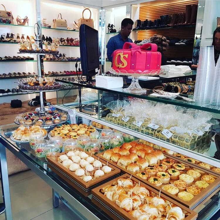 Mesa de Coffee Break empresarial com pães doces frutas e queijos